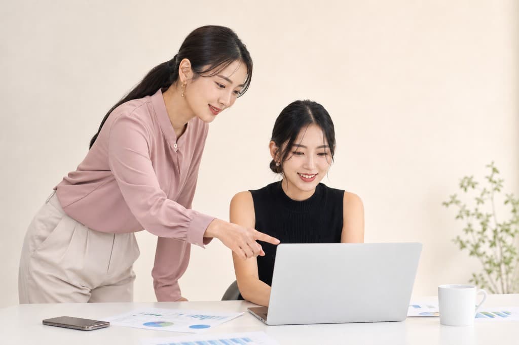 スタッフがノートパソコンの画面を指し示しながら、女性にサポートしている様子